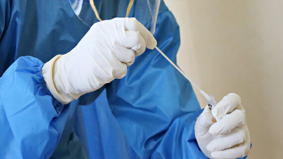 Medical technician with COVID-19 test